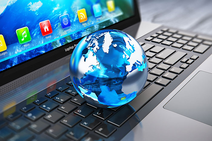 miniature globe sitting on laptop